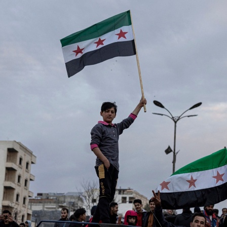 Ein Junge schwenkt im syrischen Manbij eine Flagge der Syrischen Freien Armee