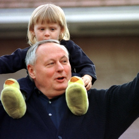 Als &#034;Privatmann&#034; winkt der zurückgetretene Bundesfinanzminister und SPD-Chef Oskar Lafontaine am Morgen des 13.3.1999 auf der Terrasse seines Hauses in Saarbrücken, auf den Schultern sein Sohn Carl-Maurice. &#034;Macht schön Eure Fotos&#034;, ermuntert Lafontaine die wartenden Journalisten.&#034; Auf Fragen, warum er von allen politischen Ämtern zurückgetreten sei, sagt Lafontaine &#034;Ich gebe keine Interviews.&#034; Er stehe hier als &#034;Privatmann&#034; und wolle jetzt bald spazierengehen.