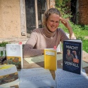 Blick auf verschiedene Bücher auf einem Tisch, dahinter Lisa Kreißler