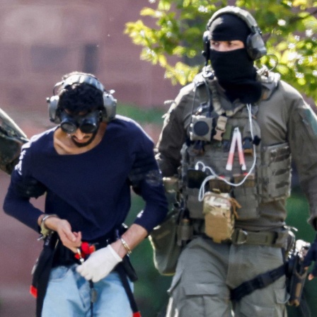 Der Verdächtige des Solinger Messerangriffs zwishcen zwei Polizeikräften (25.08.2024).