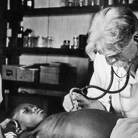 Albert Schweitzer im Urwaldhospital in Lambarene bei der Untersuchung eines Patienten