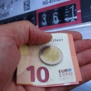 Hand mit Euros vor einem Gaszähler