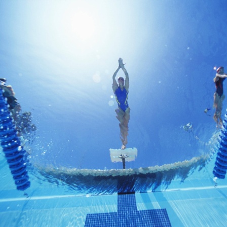 Schwimmerinnen vor dem Absprung von unter Wasser fotografiert