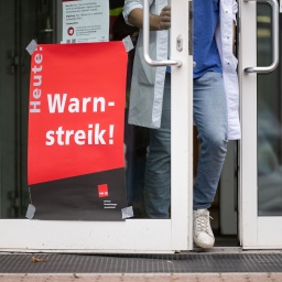 Ein Plakat mit der Aufschrift „Heute Warnstreik“ hängt am Eingang eines Gebäudes des Universitätsklinikum Tübingen.
