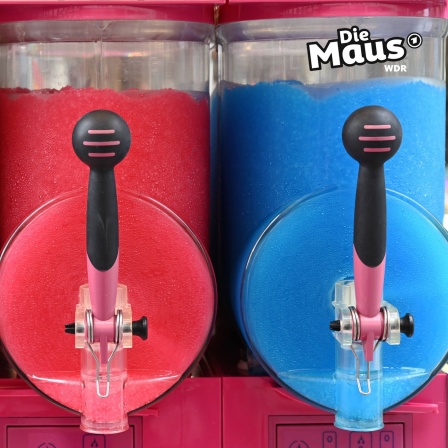 Auf dem Bild sind zwei Slush-Maschinen zu sehen, die mit rotem und blauem Slush gefüllt sind, und oben rechts ist das Logo "Die Maus" abgebildet.