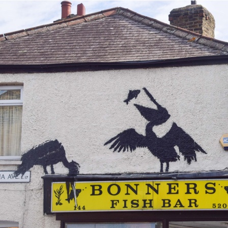 Ein Werk von Banksy, das ein Fisch fressendes Pelikanpaar über einem Fish-and-Chips-Laden zeigt, ist in Walthamstow zu sehen (09.08.2024).
