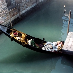 Ein Paar liegt in einer Gondel zusammen in einem einsamen, kleinen Kanal in Venedig.