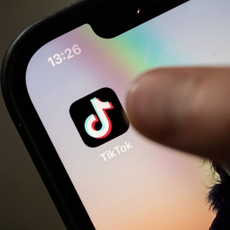 Ein Nutzer ist kurz davor, auf einem iPhone auf das Icon der App Tiktok zu drücken.