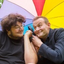 Axel Rahnisch und Devid Striesow unter einem regenbogenfarbenen Schirm