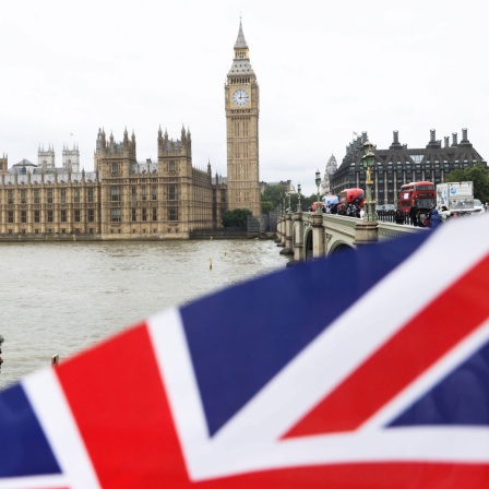 House of Parliament und die britische Fahne im Vordergrund. Symbolbild