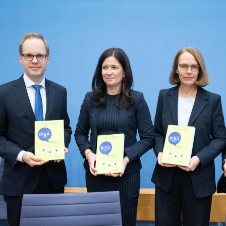 Berlin: Jens Brandenburg (FDP, l-r), Parlamentarischer Staatssekretär im Bundesministerium für Bildung und Forschung, Katharina Günther-Wünsch (CDU), Senatorin für Bildung, Jugend und Familie in Berlin und Präsidentin der Kultusministerkonferenz, Doris Lewalter, Nationale PISA-Projektleiterin, und Francesco Avvisati, Ko-Autor der PISA-Studie, halten bei der Vorstellung der Pisa-Studie 2022 in der Bundespressekonferenz Exemplare der Studie. 