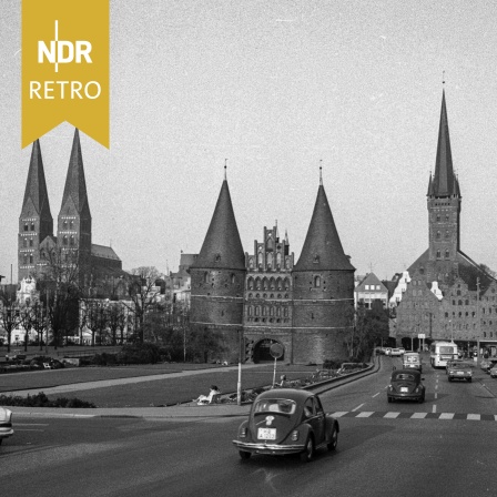 VW Käfer auf einer Straße in Lübeck vor dem Holstentor, 1960er Jahre
