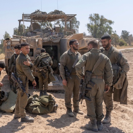 Israelische Soldaten stehen neben Mannschaftstransportern in der Nähe der Grenze zwischen Israel und Gaza.