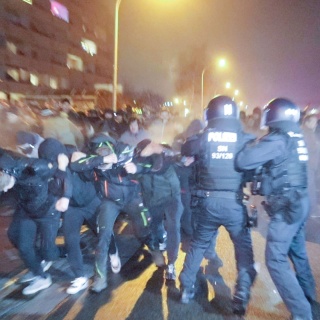 Eine Menschengruppe durchbricht eine Polizeiabsperrung