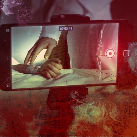 Ein inszeniertes und stilisiertes Bild zeigt wie eine Person in Kittel den Arm einer liegenden Person berührt. Die Szene doppelt sich in dem Monitor eines Smartphones, das ein Video davon aufnimmt.