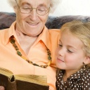 Großmutter liest ihrer Enkelin aus einem Märchenbuch vor