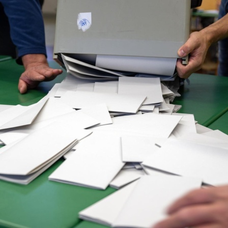 Eine Wahlurne wird ausgeleert, die Auszählung der Stimmzettel beginnt.