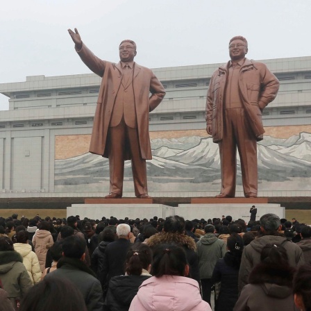 In Pjöngjang stehen Menschen vor den Statuen der ehemaligen Führer Kim Il Sung und Kim Jong Il. 
