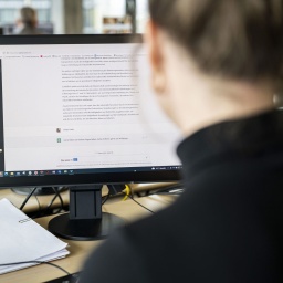 Eine Frau benuetzt ChatGPT mit einem Computer.