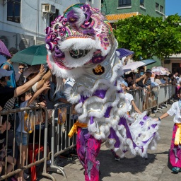 Hong Kong Cheung Chau Bun Festival, Mädchen läuft neben buntem Drache