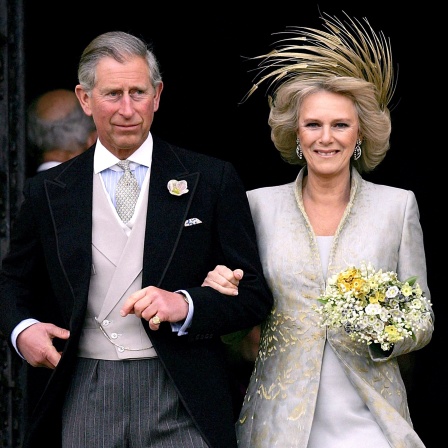 König Charles und Königin Camilla am Tag der Hochzeit nach der Kirche. Er schick im Anzug, sie in einem hellem Kostüm mit Kopfschmuck.