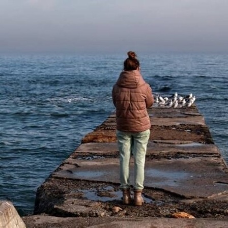 Eine Frau blickt auf das Meer.