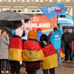 Drei mit Deutschlandfahnen behängte Teenager nehmen an einer Wahlkampfveranstaltung der AfD in Haldensleben teil.