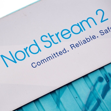 Ein Schild mit der Aufschrift Nord Stream 2 Committed Reliable Safeâ hängt im Gewerbegebiet Lubmin über einer aufgemalten Landkarte an der Erdgasempfangsstation