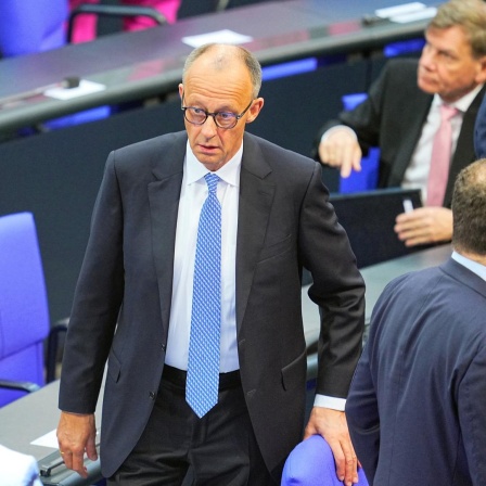 Der designierte Bundeskanzler Friedrich Merz (CDU, M) reagiert im Bundestag bei der Kanzlerwahl. 