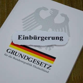 Auf einem Grundgesetz liegt das Wort Einbürgerung.