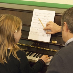 Symbolbild: Musiklehrer und Schülerin am Klavier
