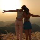 2 Frauen umarmen einander vor einem Sonnenuntergang