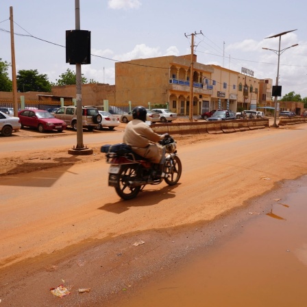 Ein Motorradfahrer fährt auf einer staubigen Straße in Niger.