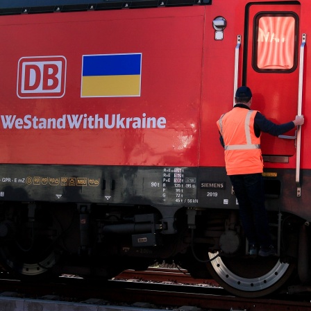 Der Lokführer eines Zuges mit Hilfsgütern für die Ukraine der DB-Schienenbrücke steigt vor der Abfahrt im Westhafen die Leiter zur Fahrkabine hinauf. 