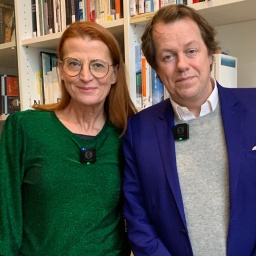 Tom Parker Bowles und Royalexpertin Annelie Malun stehen vor einem großen Bücherregal.