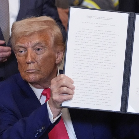 US-Präsident Donald Trump hält eine unterzeichnete Anordnung während einer Veranstaltung im East Room des Weißen Hauses. 