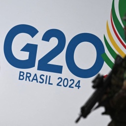 Ein Soldat patrulliert vor einer Wand mit dem logo des G20-Gipfels 2024