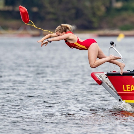 Rettungsschwimmerin der DLRG (Deutsche Lebens-Rettungs-Gesellschaft), springt während einer Übung in den Halterner Stausee.