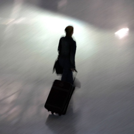 Frau mit Rollkoffer auf dem Flughafen Frankfurt am Main