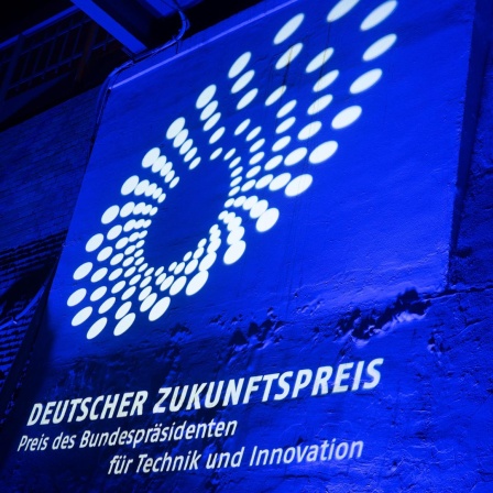 Das Logo des Zukunftspreises wird an eine Wand projiziert. 