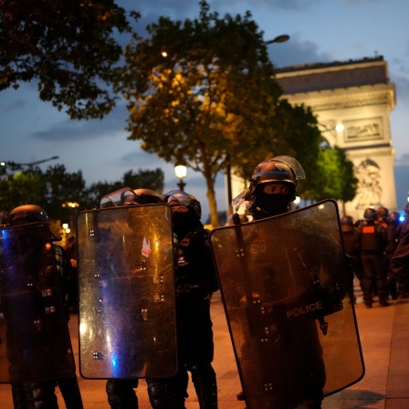 Polizisten patrouillieren vor dem Arc de Triomphe auf der Champs Elysees. Aufgrund der anhaltenden Unruhen in Frankreich sollen in der Nacht zum Sonntag erneut 45 000 Polizisten im Einsatz sein.
