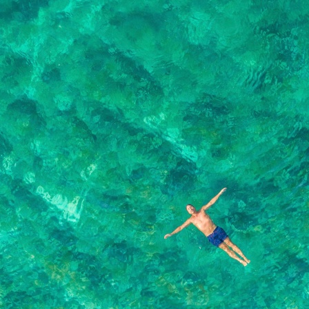 Mensch lässt sich im Meer auf dem Rücken treiben