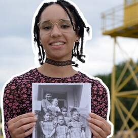 Community-Reporterin Amanda Godwin hält ein Schwarz-weiß-Foto mit schwarzen Kinder in den Händen