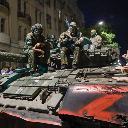 Angehörige des Militärunternehmens Wagner Group sitzen auf einem Panzer auf einer Straße in Rostow am Don, Russland, bevor sie einen Bereich im Hauptquartier des südlichen Militärbezirks verlassen.