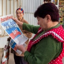 Scheinreferendum in Luhansk: Eine Freiwillige der regionalen Wahlkommission in Luhansk verteilt Wahlwerbe-Zeitungen an zwei Frauen.
