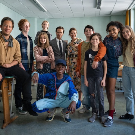 Schauspielerinnen und Schauspieler haben sich für ein Gruppenfoto im Klassenraum eingefunden, der als Drehort des Films &#034;Das Fliegende Klassenzimmer&#034; gedient hat.