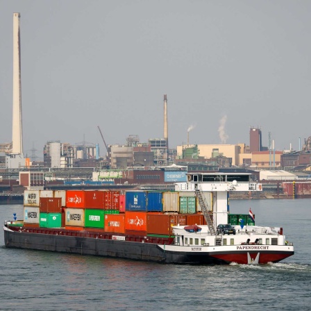 Frachtschiff fährt auf dem Rhein vorbei am Chemiewerk Chempark (Bild: imago images/Rupert Oberhäuser)