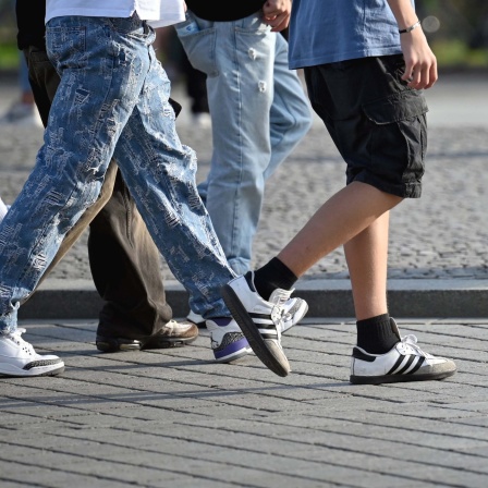 Symbolfoto: Ausschnitt von Jugendlichen in Jeans und Turnschuhen.