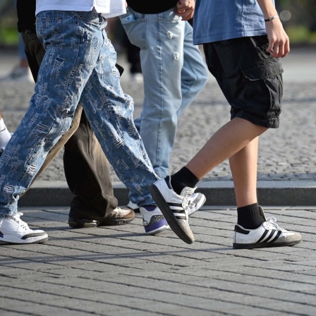 Symbolfoto: Ausschnitt von Jugendlichen in Jeans und Turnschuhen.