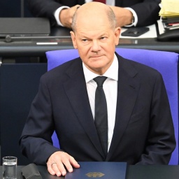 Bundeskanzler Scholz sitzt vor seiner Regierungserklärung an seinem Platz im Bundestag.